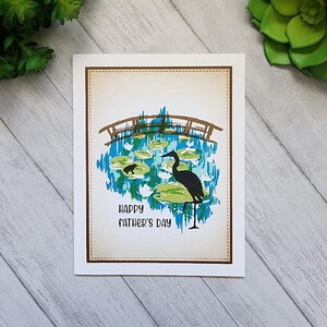 Carte de fête des pères - « Bonne fête des pères » scène d'étang marron avec pont, cigogne et grenouille Carte de voeux vierge