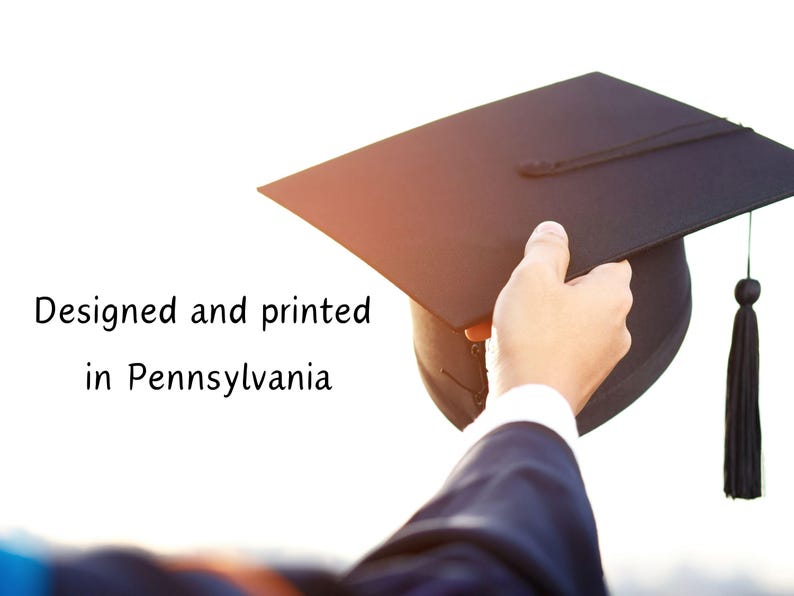 May include: A black graduation cap with a tassel is held by a hand wearing a dark blue suit. The text "Designed and printed in Pennsylvania" is visible in the image.