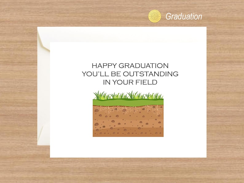 Op de afbeelding: Een witte kaart met de tekst "Happy Graduation You'll Be Outstanding In Your Field" en een cartoon afbeelding van een stukje gras en aarde.