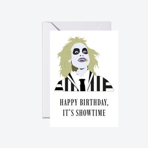 May include: A birthday card featuring a black and white striped character with green hair and a white collar. The text on the card reads "Happy Birthday, It's Showtime".
