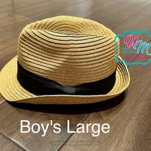May include: A straw hat with a black band. The hat is brown and has a wide brim. The text "Boy's Large" is written below the hat.