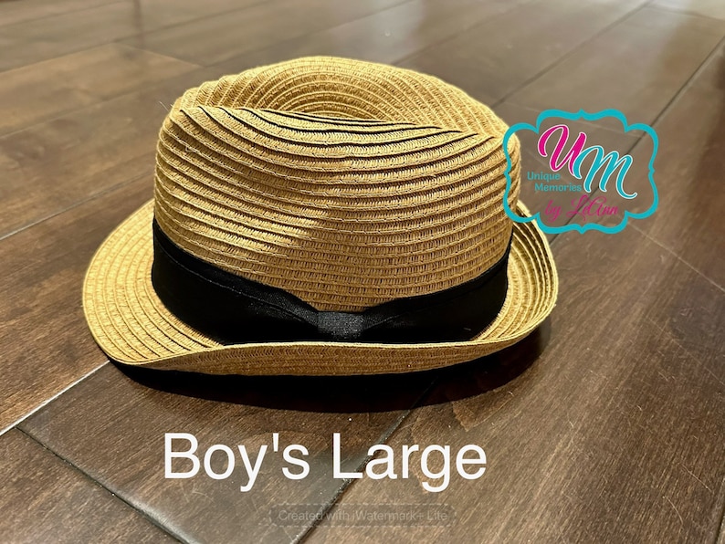 May include: A straw hat with a black band. The hat is brown and has a wide brim. The text "Boy's Large" is written below the hat.