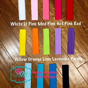 Puede incluir: Un conjunto de 12 diademas estrechas de color s&oacute;lido en varios colores, incluyendo blanco, rosa, rojo, amarillo, naranja, lima, lavanda, morado, aguamarina, turquesa, azul real y negro. Las diademas est&aacute;n dispuestas en tres filas de cuatro, con los colores etiquetados debajo de cada fila. El texto "Unique Memories by L.B.N." y "Custom Embroidery & Vinyl Designs" tambi&eacute;n es visible en la imagen.