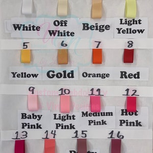 May include: A colour chart displaying sixteen ribbon swatches in diverse shades. Colours include white, off-white, beige, yellow, gold, orange, red, and various shades of pink and purple. Each swatch is labelled with its corresponding colour name.