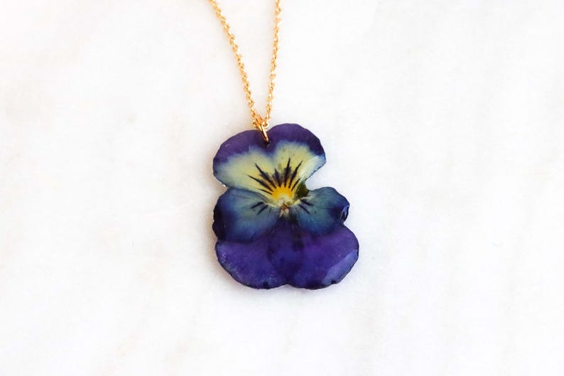 Pressed pansy flower pendant preserved in clear resin on gold chain