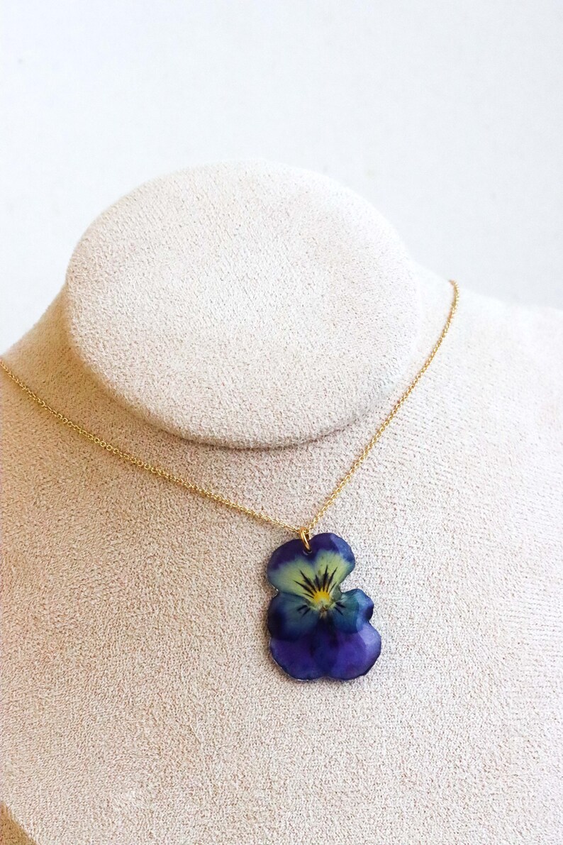 Real pansy flower necklace pendant on gold chain worn on neck