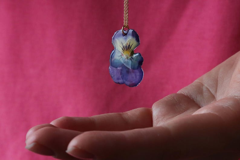 Pressed pansy flower necklace pendant in hand