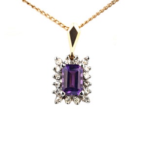 May include: A gold chain necklace with a pendant featuring a large purple amethyst gemstone surrounded by smaller diamonds.