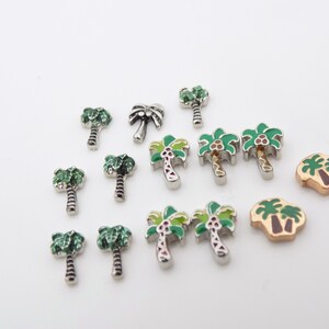 May include: Assortment of palm tree charms in silver and gold tones. The charms feature green, brown, and yellow enamel details.