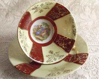 Elegant antique porcelain tea duo with Burgundy red and yellowish white radiating shapes of colour and a medalion with a biblical scene