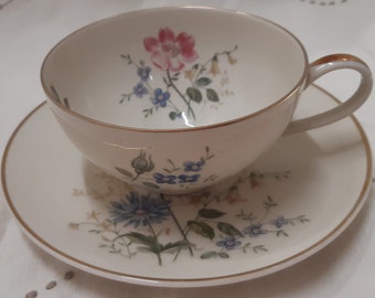 Bavarian, German fine porcelain teacup and saucer with eggshell off white colour and floral clusters.  pink blue off white flowers