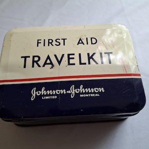 First Aid Travel Kit tin by Johnson and Johnson, vintage collectable tin, some dents and child drew on it, some came off. Bottom paper ad
