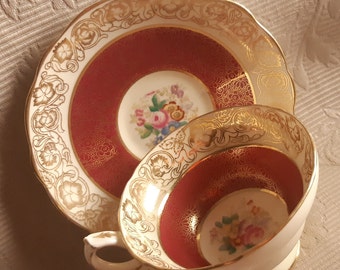 Discounted Alsager tea duo has rust red bands covered in chintz gold and gold on cream borders with a circle of meadow flowers in the middle