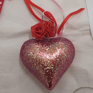 Vintage Glas Herz Ornament für den Baum hat rotes Glas mit Glitter und roten und rosa Seidenblumen Rosen und Band an der Spitze hinzugefügt.