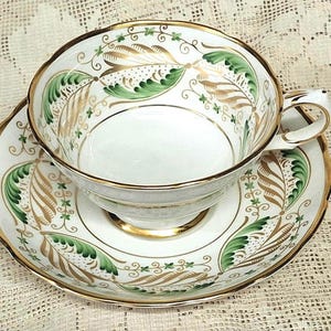 Elegant Grosvenor China teacup and saucer with green and gold stylizes leaved on white , vintage tea duo
