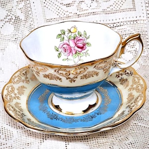 Taza de té y platillo vintage Royal Albert May Fair con una banda de azul medio, con diseños de filigrana dorada y rosas de té en forma de Malvern.