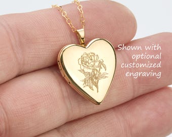 May include: A gold-toned heart-shaped locket pendant on a delicate chain, featuring a fine-line floral engraving on the front surface. The text "Shown with optional customized engraving" is visible next to the locket.