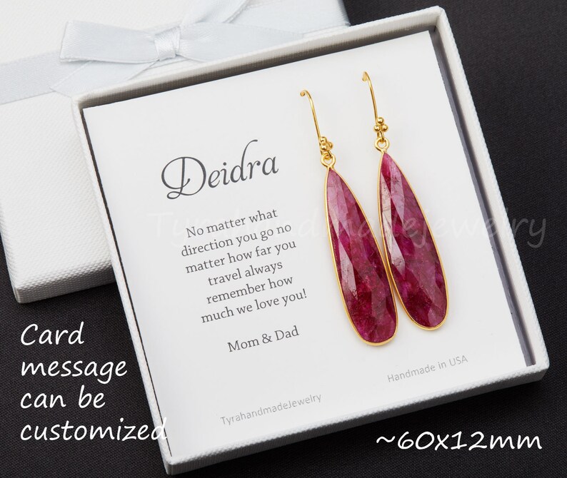 以下が含まれることがあります： 白いギフトボックスには、「Deidra どんな方向に行っても、どんなに遠くへ旅しても、いつも私たちがどれだけ愛しているか忘れないでね！ママとパパ」と書かれたカードが入っています。ボックスには、ピンクの宝石のドロップが付いたゴールドのイヤリングのペアが入っています。イヤリングは約60mm x 12mmです。