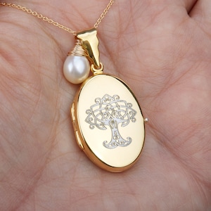May include: Gold-tone oval locket necklace with a Celtic tree design. A small white pearl hangs from the chain. The locket is approximately 1 inch in length and is suspended from a delicate gold chain.