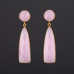 Peut inclure: Une paire de boucles d'oreilles pendantes avec des gouttes de pierres précieuses roses. Le haut de chaque boucle d'oreille est orné d'une pierre précieuse rose ronde.