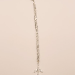 May include: A silver chain bracelet with a small airplane charm attached to the end.