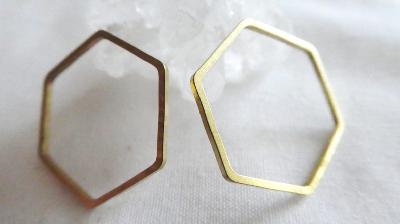Peut inclure: Deux cadres hexagonaux ouverts en m&eacute;tal dor&eacute;. Les cadres sont fins, plats et pr&eacute;sentent une surface lisse et r&eacute;fl&eacute;chissante. Chaque pi&egrave;ce forme une forme g&eacute;om&eacute;trique compl&egrave;te &agrave; six c&ocirc;t&eacute;s avec des coins nets et d&eacute;finis, pr&eacute;sent&eacute;s individuellement.