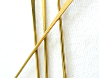 Peut inclure: Quatre aiguilles d'horloge dorées, chacune avec un petit trou en haut. Les aiguilles sont disposées en forme de croix.