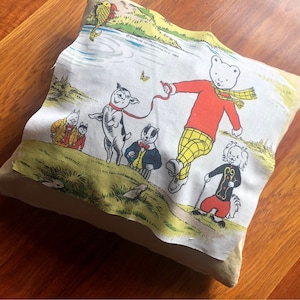 May include: A white pillowcase featuring a colourful illustration of a bear and other animals. The bear is wearing a red shirt and yellow trousers. The text "Express Newspapers Ltd. © 1988" is printed on the pillowcase.