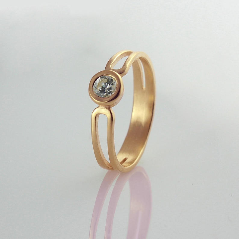 Solid 14k rose gold engagement ring with a round cut natural diamond. Simple and modern diamond promise ring for her.
Make her feel special with this somewhat alternative solitaire diamond engagement ring. It is modern and simple in style.