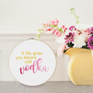 May include: White embroidery hoop with the text "If life gives you lemons add vodka" in pink and yellow lettering.