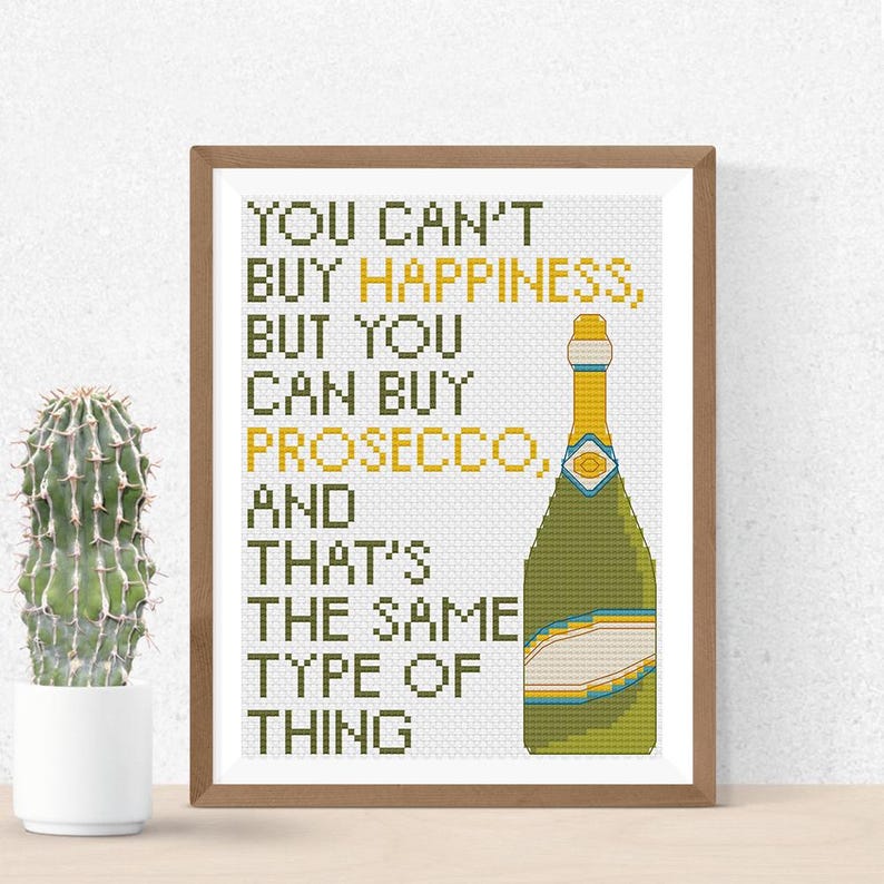 May include: A framed print with a white background and green text that reads "You can't buy happiness, but you can buy prosecco, and that's the same type of thing". A green and yellow illustration of a bottle of prosecco is on the right side of the print.