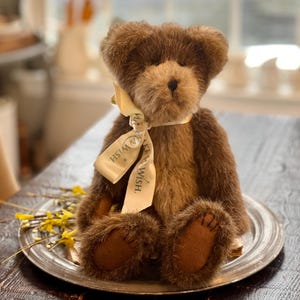 May include: A brown teddy bear wearing a yellow ribbon with the text "Make a Wish." The bear is sitting on a silver platter.