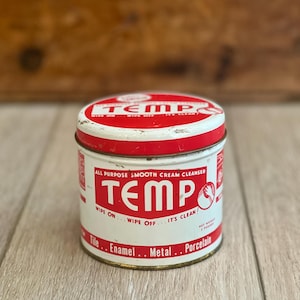 May include: Vintage Tempo all-purpose smooth cream cleanser tin. The white and red tin features the word "TEMP" in large red letters. The tin is labeled for use on tile, enamel, metal, and porcelain. The net weight is 2 pounds.