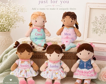 Puede incluir: Cinco muñecas de peluche con nombres bordados en su ropa. Dos son muñecas sirena con cola y tres llevan vestidos. Las muñecas tienen varios colores y estilos de pelo, y cada una está personalizada con un nombre único: Cora, Mira, Natalee, Jubilee y Fran.