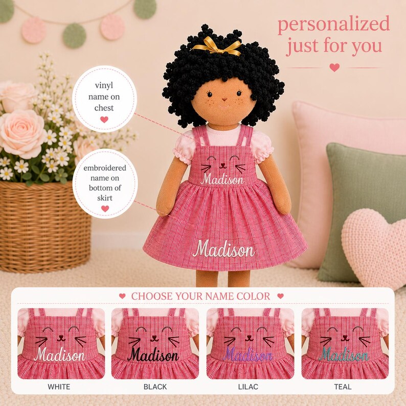 May include: A plush doll with black curly hair and a gold bow, wearing a pink dress with the name "Madison" embroidered on the chest and skirt. The dress has a cat face design. The image shows options for name color.