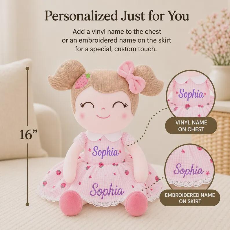 May include: A plush doll with a pink dress and the name "Sophia" embroidered on the chest and skirt. The doll has brown hair, a pink bow, and is 16 inches tall. The text reads "Personalized Just for You".