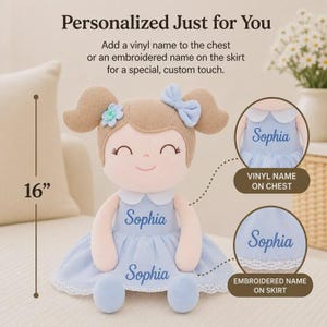 May include: A plush doll with a light blue dress and the name "Sophia" on the chest and skirt. The doll is 16 inches tall and has brown hair with a blue bow and flower accents. The text "Personalized Just for You" is at the top.