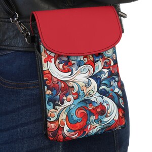 Puede incluir: Una funda para teléfono con estampado rojo y azul con una solapa roja. La funda se lleva en la cadera de una persona.