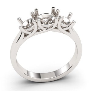 May include: A silver ring with three prongs for setting stones. The prongs are in a curved, three-stone setting.