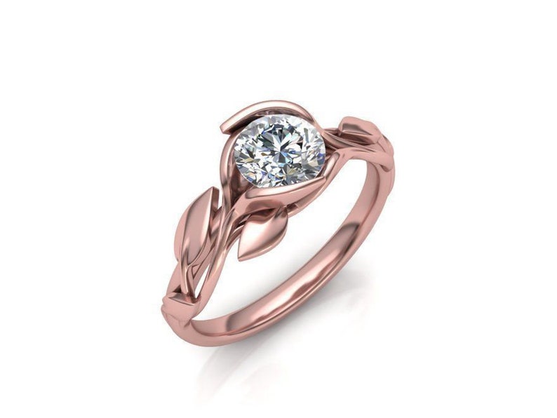 May include: A rose gold engagement ring with a round diamond set in a delicate floral design.