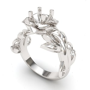 May include: A silver ring with a rose design. The rose is the center of the ring and has a setting for a stone. The ring is made of intricate details and has a delicate design.