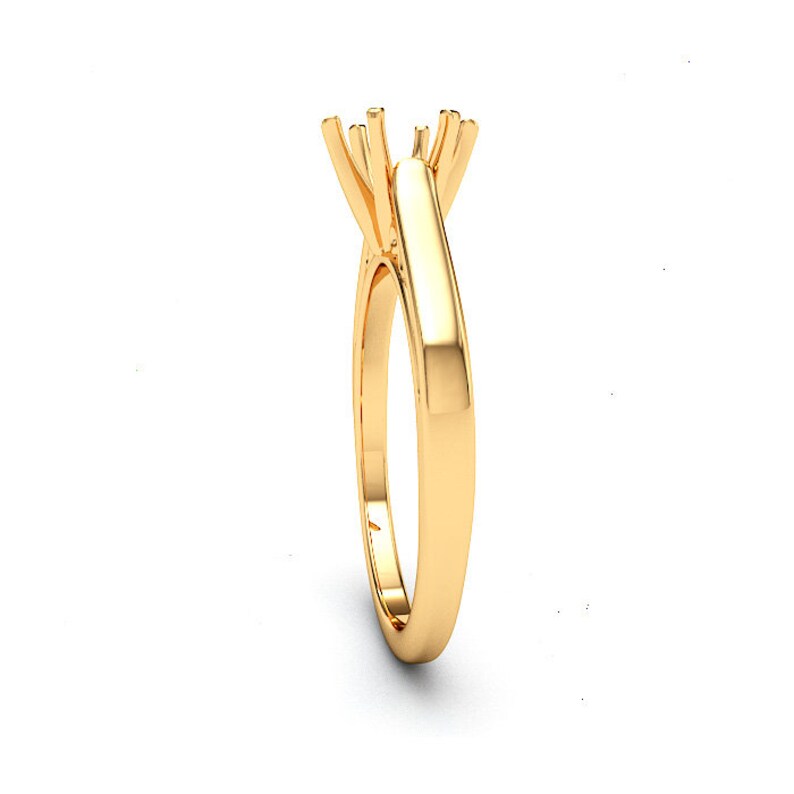 May include: A gold solitaire engagement ring setting with a prong setting for a center stone.