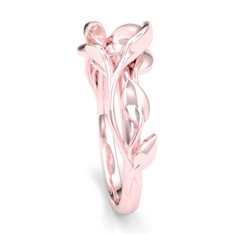 May include: A rose gold ring with a delicate design of intertwined leaves and branches. The ring is a statement piece with a unique and intricate design.
