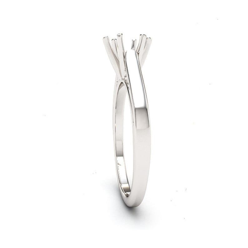 May include: A silver ring setting with a prong setting for a center stone.