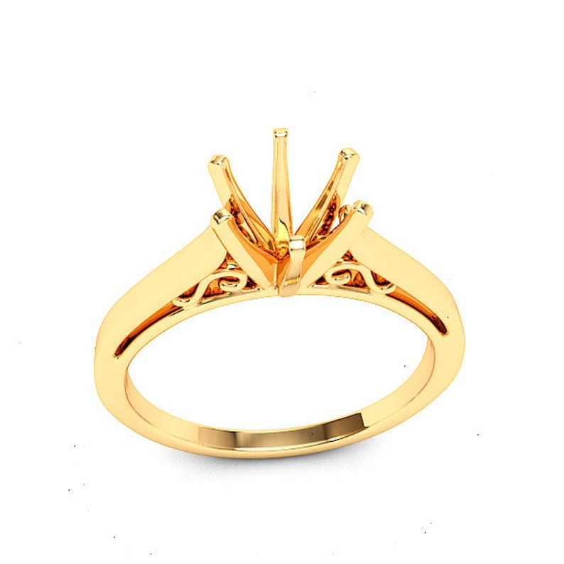 May include: A gold ring setting with a delicate filigree design. The setting is designed to hold a large center stone.