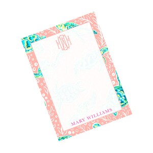 May include: Pink notepad with a white border and a sea turtle design. The notepad has a monogram "MWM" and the name "MARY WILLIAMS" printed at the bottom.