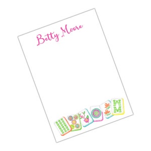 May include: White notepad with the name "Betty Moore" printed in pink at the top. The bottom of the notepad features a row of colorful mahjong tiles with green bamboo, flowers, and circles.
