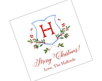 May include: A white Christmas card with a blue and red watercolour design. The design features a shield with the letter "H" in red, surrounded by green leaves and red berries. The text "Merry Christmas! Love, The Halfords" is written in red cursive.