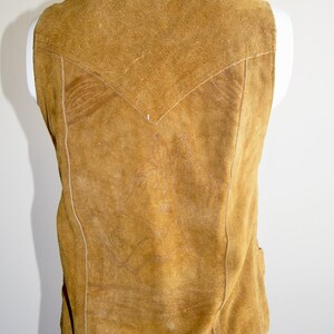 May include: A brown suede vest with a V-shaped yoke and a straight hem.