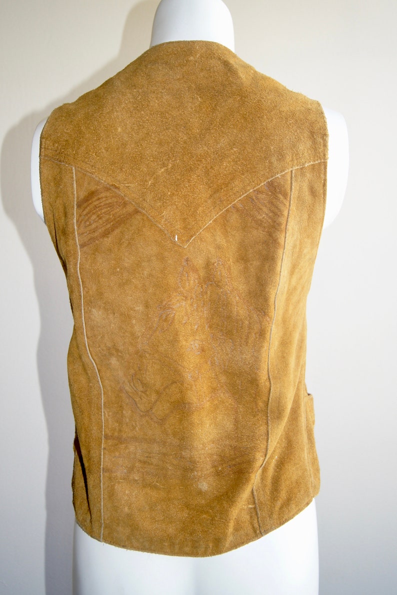 May include: A brown suede vest with a V-shaped yoke and a straight hem.